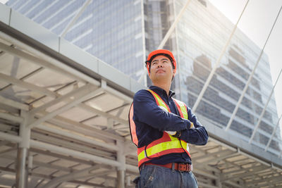 Architect standing against buildings in city