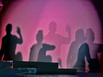 Shadow of people pink wall