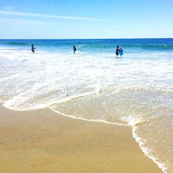 People on beach against sky