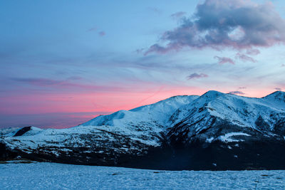 Scenic view of snowcapped mountains against sky during sunset