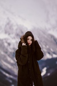 Portrait of young woman standing in snow