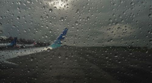 Cloudy sky seen through wet glass window