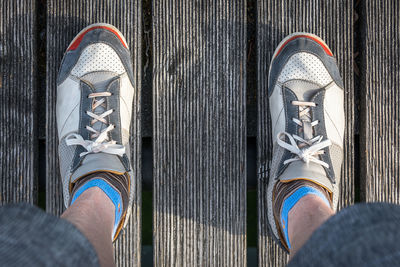 Low section of man standing on tiled floor