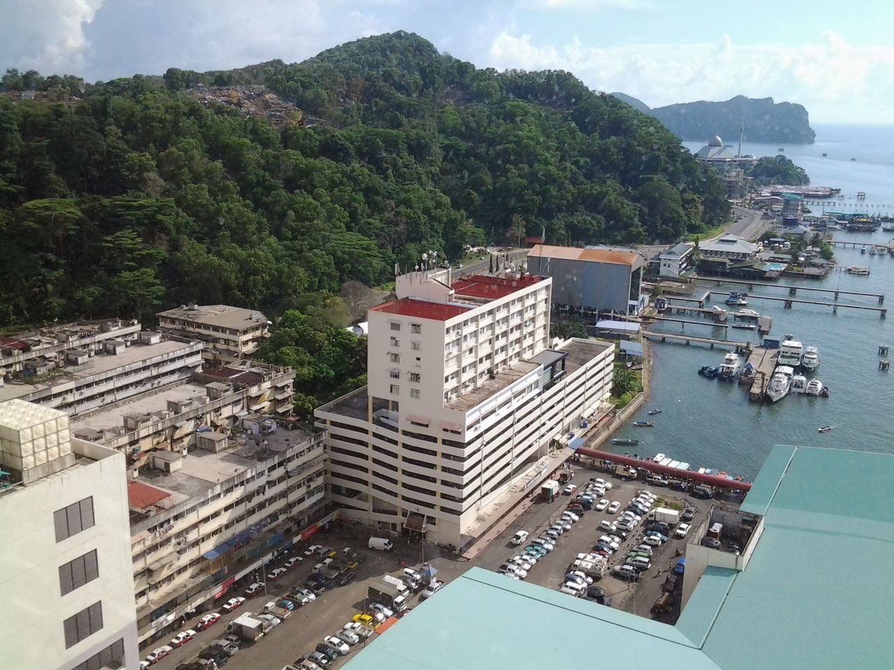 high angle view, building exterior, architecture, tree, outdoors, day, mountain, built structure, no people, sky, cityscape, city, nature, water