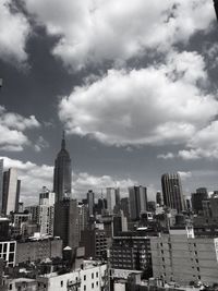 Modern cityscape against cloudy sky