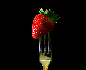 Close-up of strawberry over black background