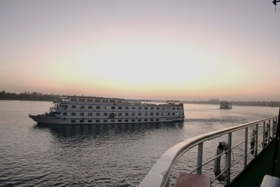 Cruise ships sailing in sea against sky during sunset