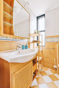 Rear view of woman washing hands in bathroom