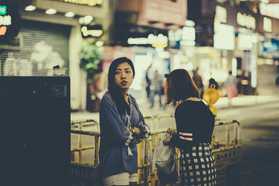 People standing in front of building at night