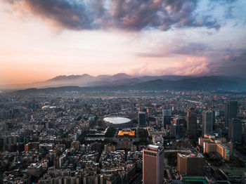 High angle view of city buildings against sky during sunset