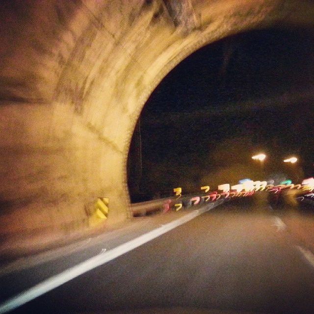 illuminated, indoors, tunnel, transportation, arch, the way forward, lighting equipment, architecture, built structure, diminishing perspective, night, ceiling, blurred motion, light - natural phenomenon, road, travel, vanishing point, no people, motion, electric light