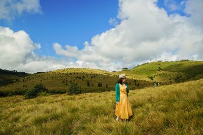 Full length of woman standing on landscape against sky