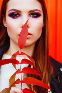 Close-up portrait of a young woman holding leaves