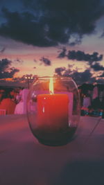 Close-up of drink against sky at sunset