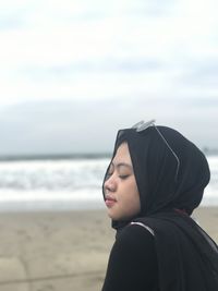 Portrait of woman looking at sea against sky