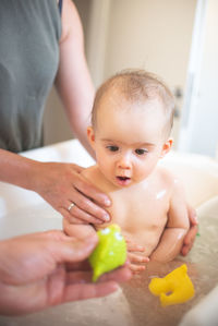 6 month baby bathing concept. baby in bath focused on a toy. baby development