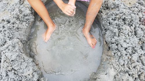 Low section of woman legs on sand at beach