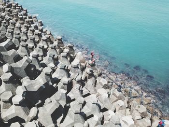 High angle view of people on groynes fishing in sea