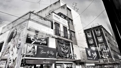 Low angle view of text on building against sky