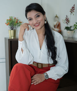 Portrait of a smiling young woman sitting at home