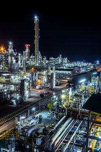 High angle view of illuminated factory against sky at night