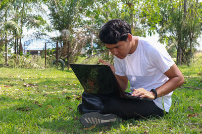 Young man sitting on field