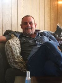 Portrait of smiling man sitting on sofa at home