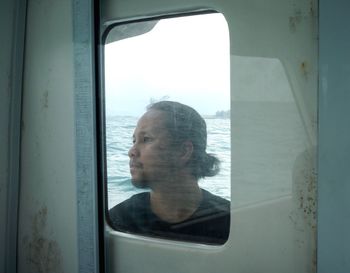 Portrait of man looking through window