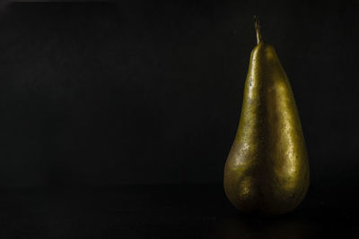 Close-up of lemon on table against black background