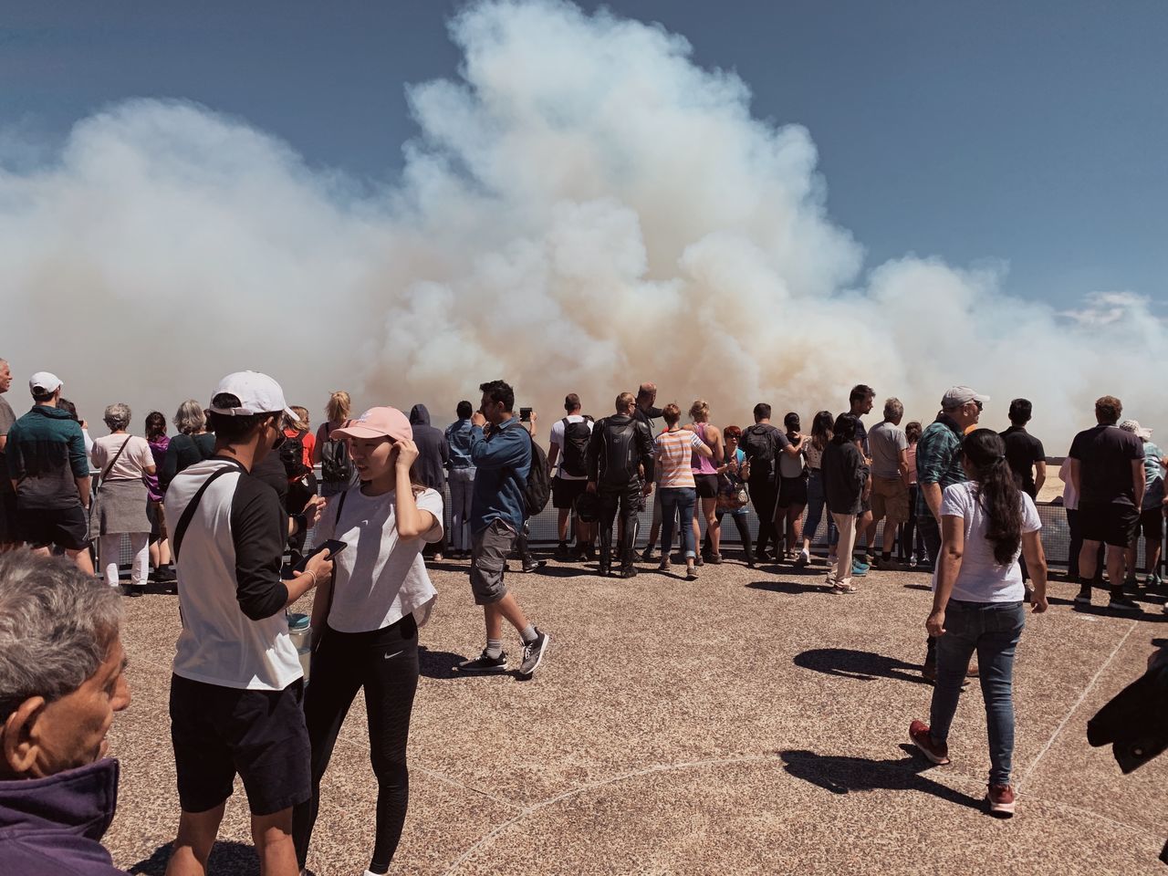 crowd, large group of people, real people, group of people, smoke - physical structure, men, sky, nature, women, day, adult, standing, outdoors, leisure activity, lifestyles, casual clothing, land, event, rear view, spectator, pollution