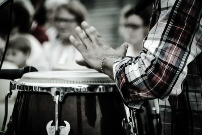 Midsection of man playing drum