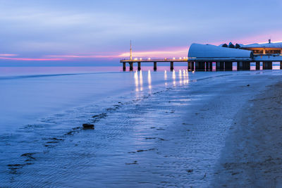 Pier on sea against sky at sunset