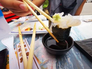 Midsection of person holding food on table