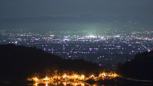 High angle view of illuminated buildings against sky at night