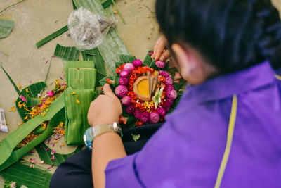 Midsection of man holding flower bouquet