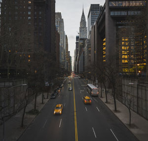 Traffic on road amidst buildings in city