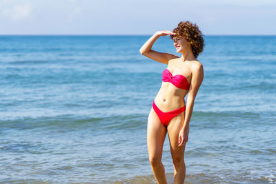 Rear view of woman standing at beach