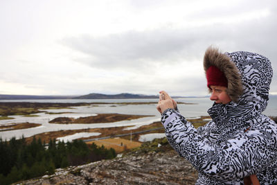 Woman with umbrella in winter against sky