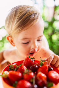 Close-up portrait of girl holding strawberry