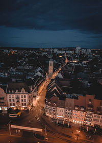 High angle view of illuminated city street and buildings at night