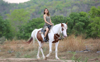 Full length of woman riding horse