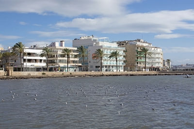 Buildings in city against cloudy sky