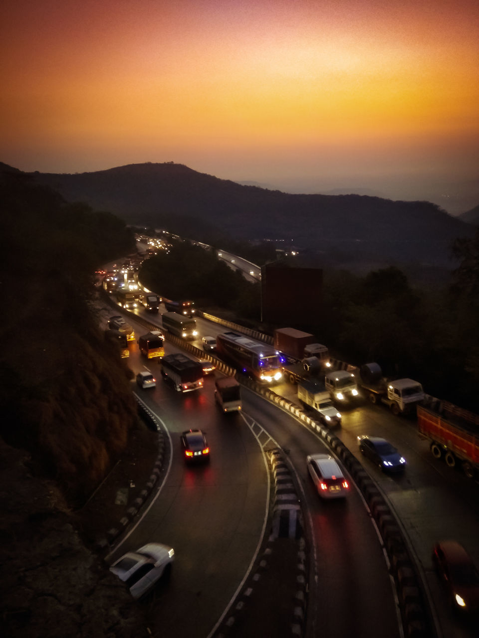 HIGH ANGLE VIEW OF ILLUMINATED CITY STREET DURING SUNSET