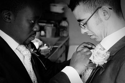 Best man fixing tie of groom