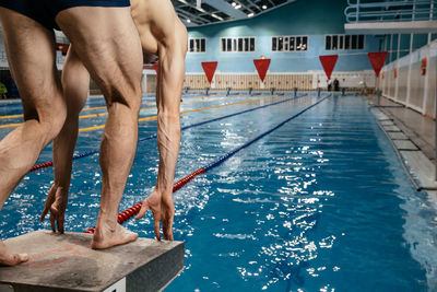 Low section of people swimming in pool