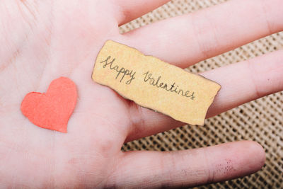 Close-up of hand holding text with heart shape