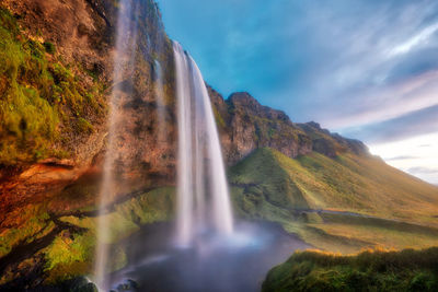 Scenic view of waterfall against sky