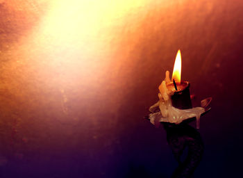 Close-up of lit candle on table