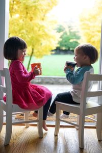 Boy sitting on chair at home