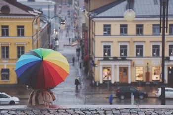 Rear view of woman with colorful umbrella in city